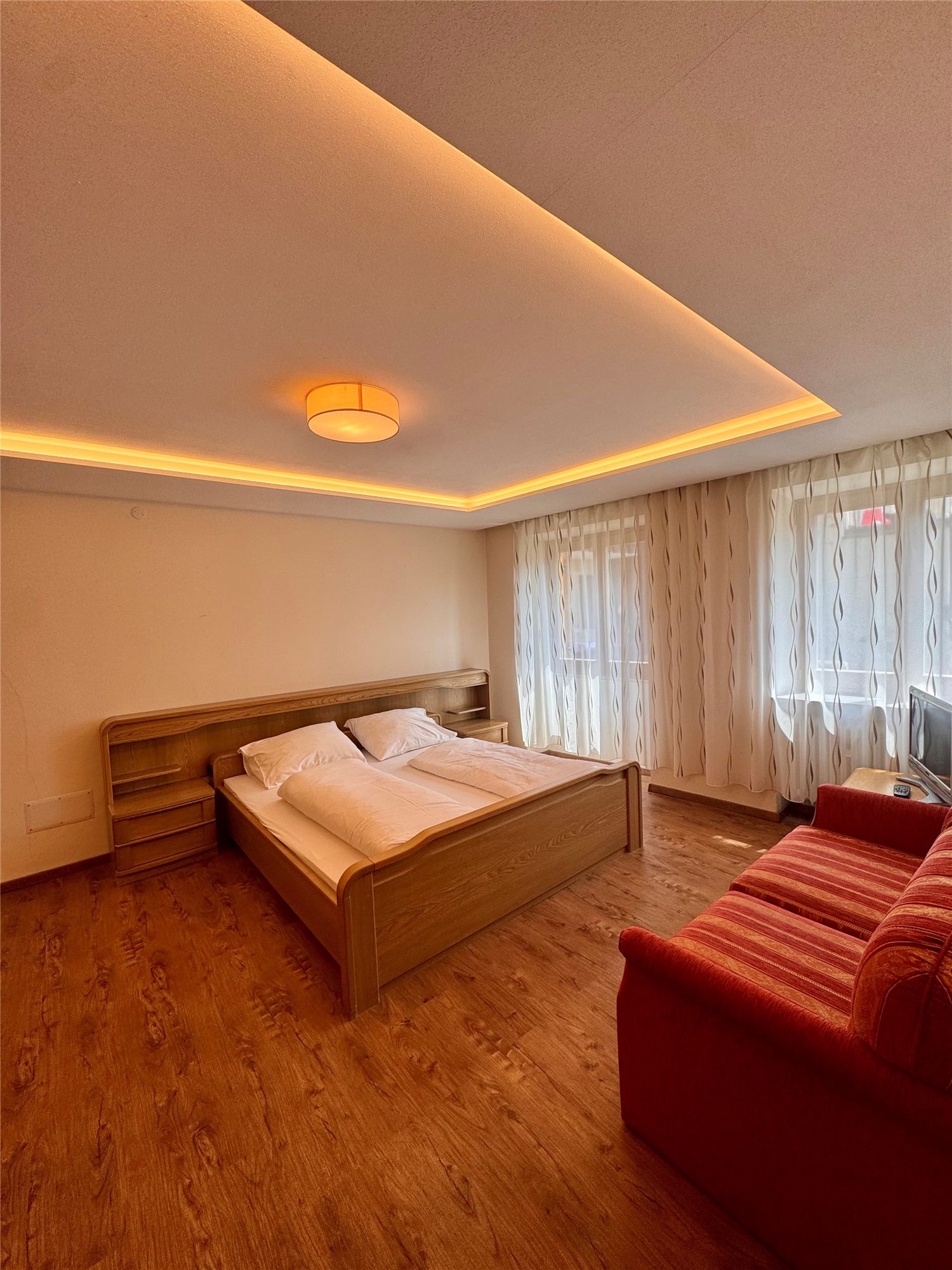 Zimmer mit Doppelbett und rotem Sofa im Hotel Goldenes Kreuz