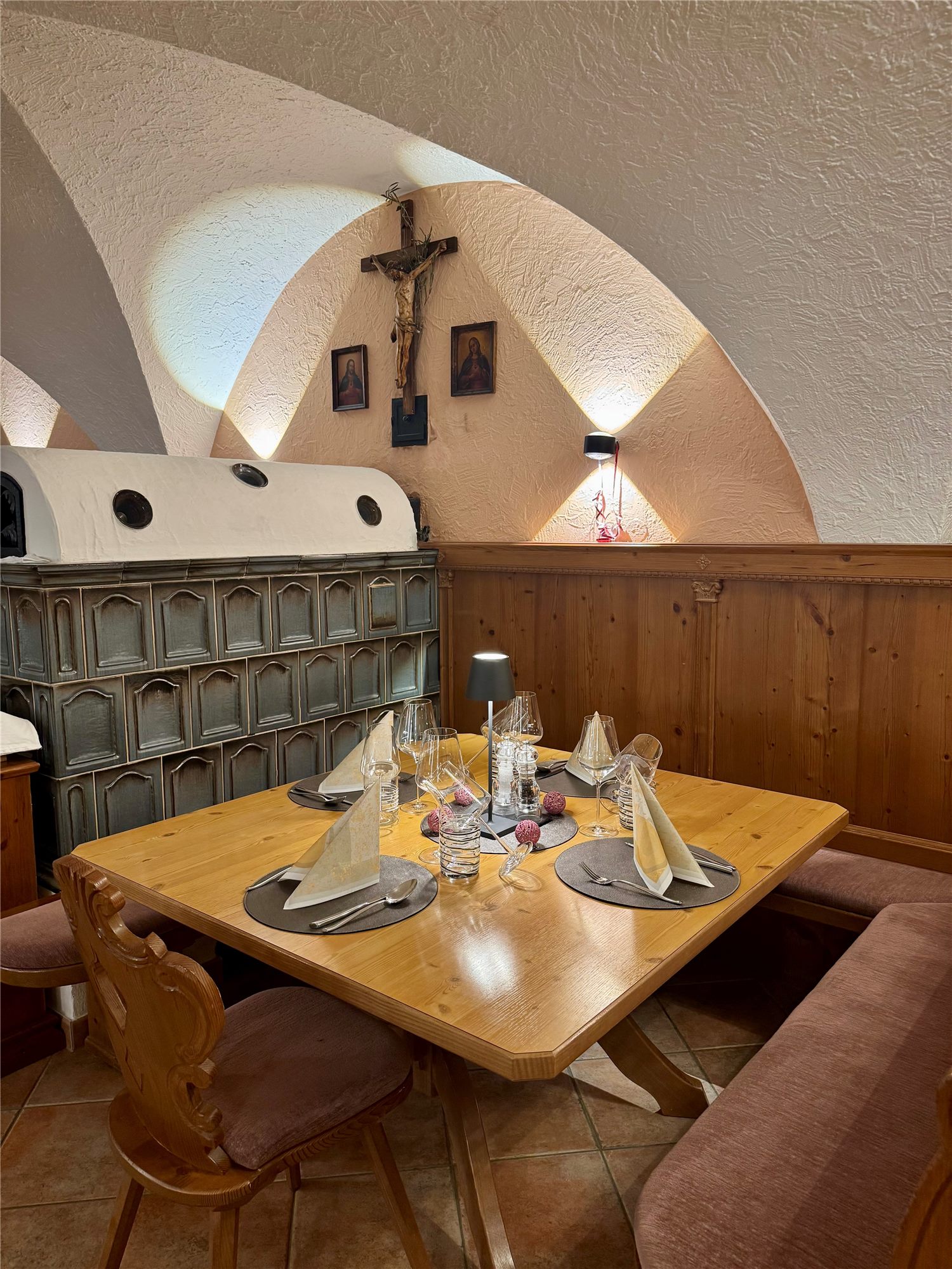 Stube mit Kachelofen und gedecktem Tisch